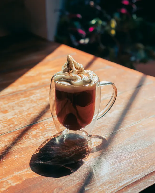 Bebida caliente con espuma en taza de cristal