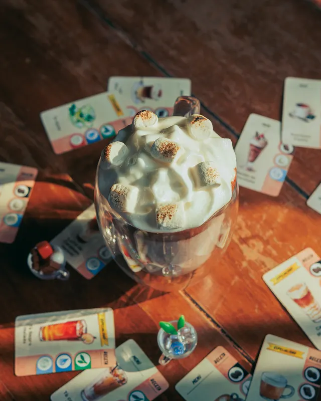 Bebida con malvaviscos entre cartas de juego