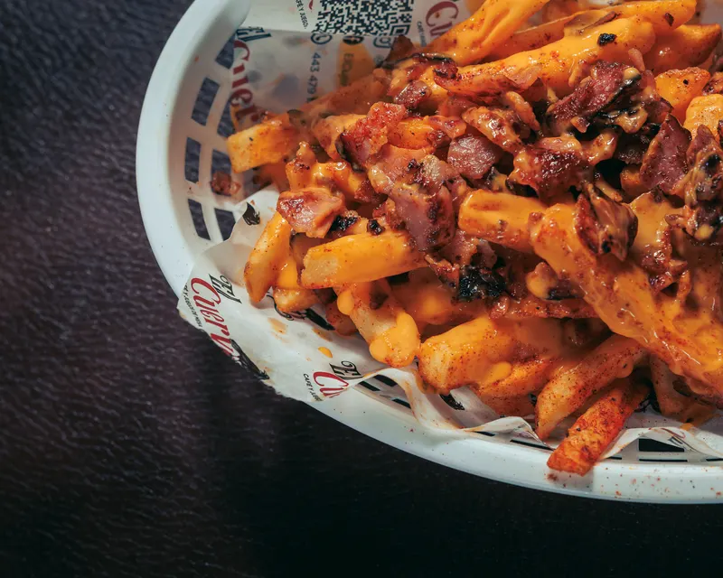 Papas gajo con salsa en una canasta